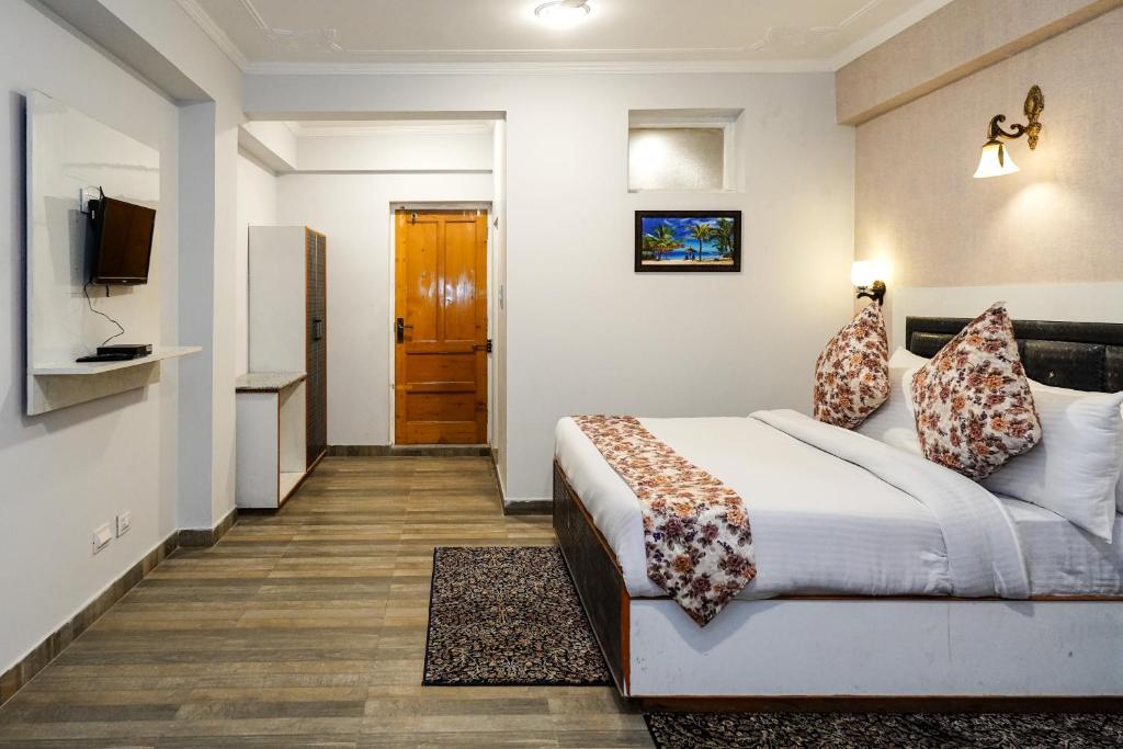 um quarto de hotel com uma cama e uma televisão em Click Sunburry Hotel Srinagar em Srinagar