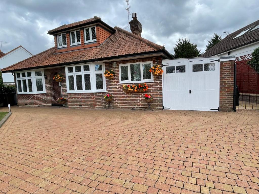 ein Backsteinhaus mit weißen Türen und einer Ziegelsteinfahrt in der Unterkunft Ragged Hall Lane in St Albans