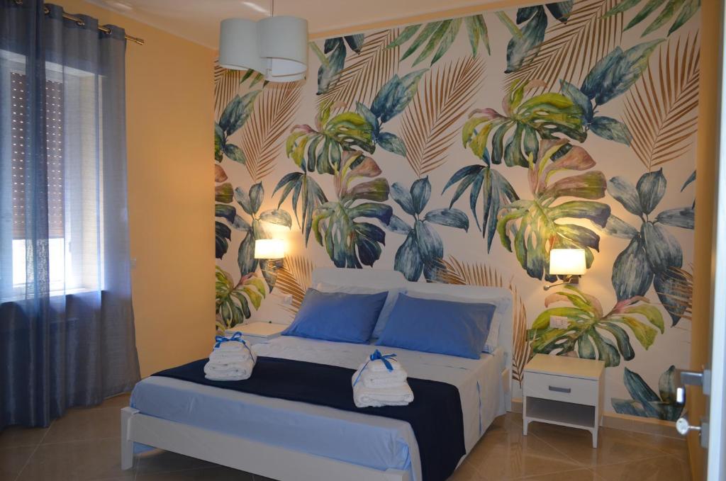 a bedroom with a bed with a tropical wallpaper at Raggio di Sole in Gaeta