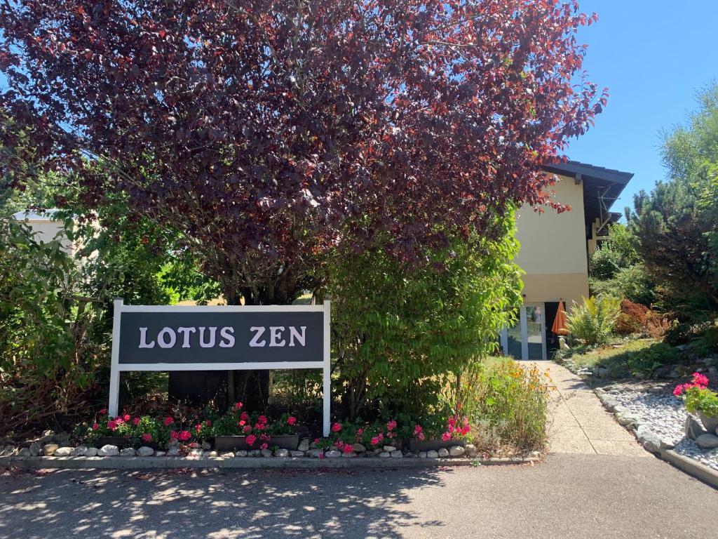 um sinal em frente a um edifício com uma árvore em Le lotus zen 
