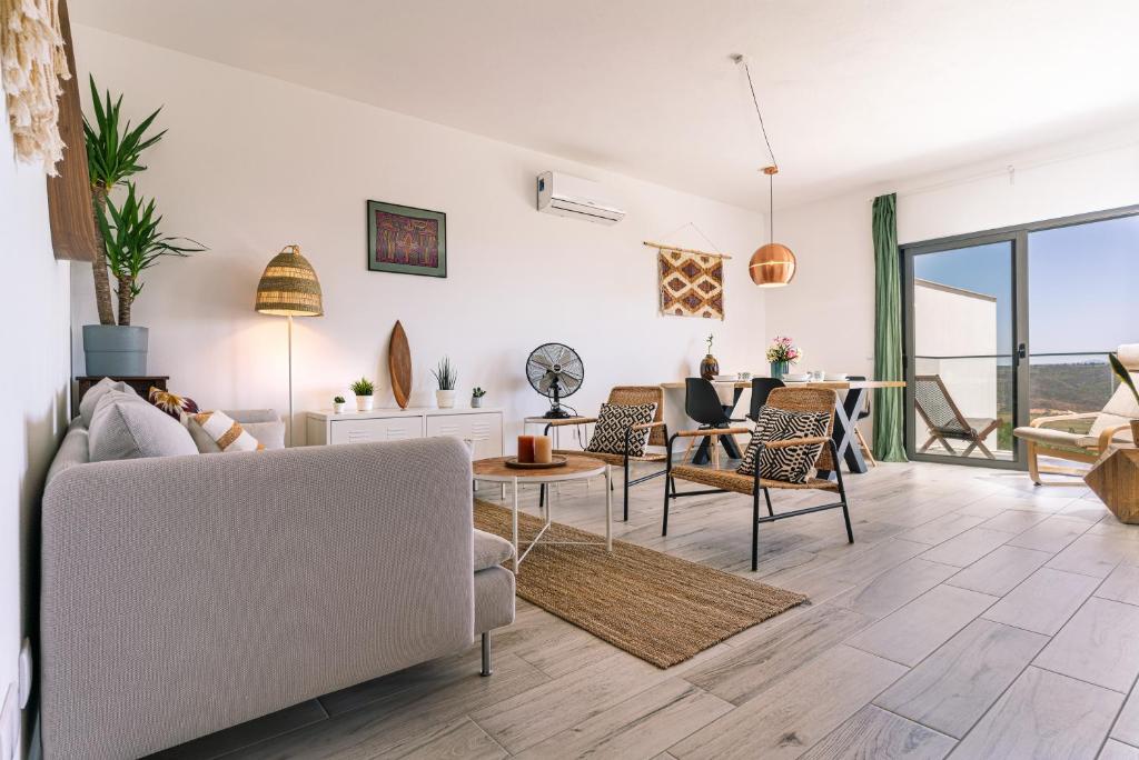 - un salon avec un canapé et des chaises dans l'établissement Surf & Beach Apartment, à Aljezur