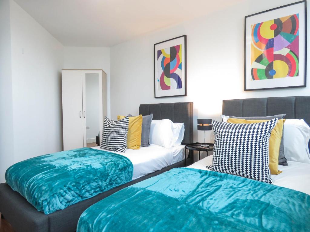 2 Betten in einem blau-weißen Zimmer in der Unterkunft Tudors eSuites Five Ways Two Bedroom Apartment in Birmingham