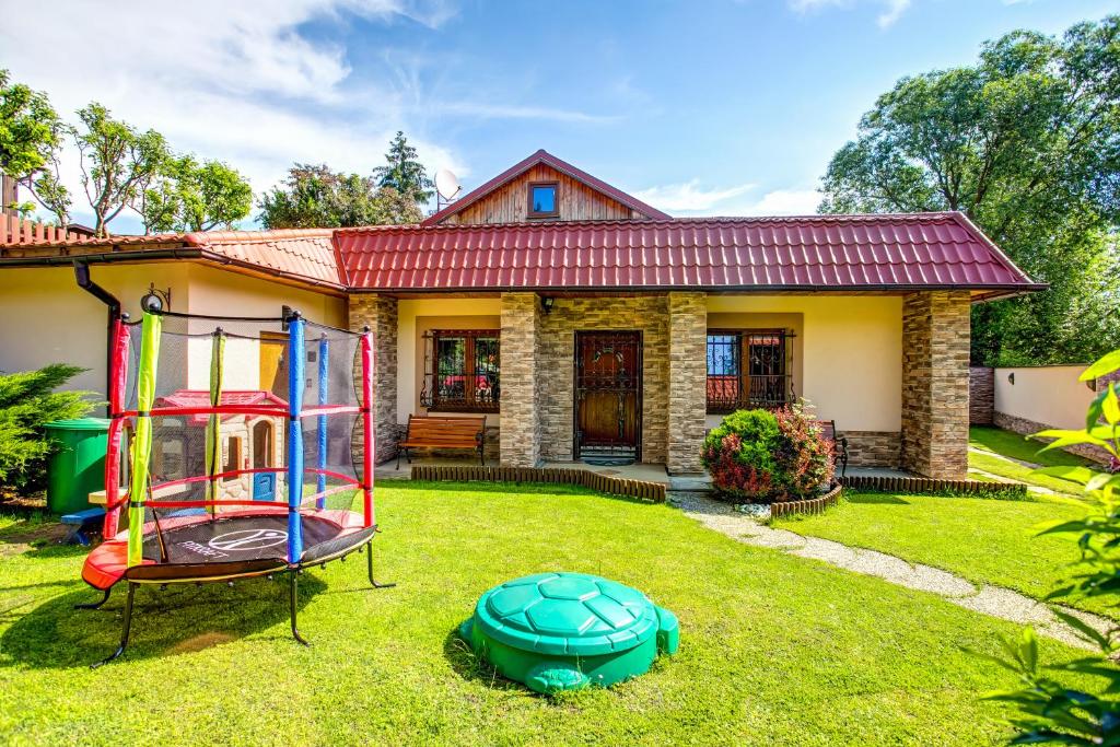 a house with a playground in the yard at Apartmanovy dom Cottage in Liptovský Ján