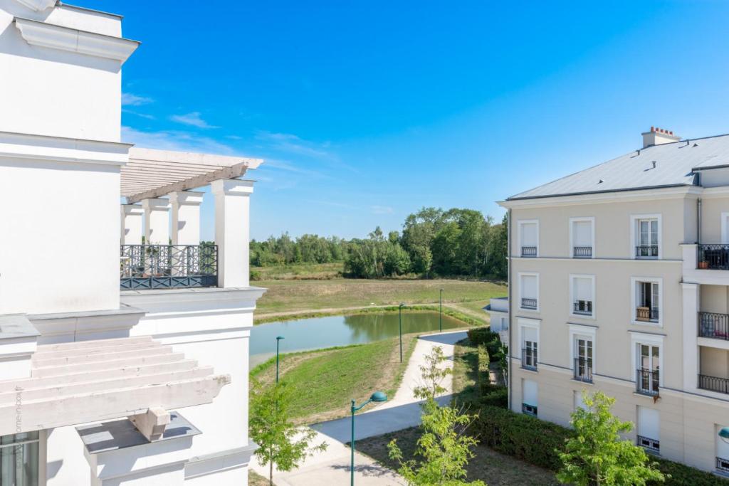 an apartment building with a view of a pond at Happy Guest House in Serris