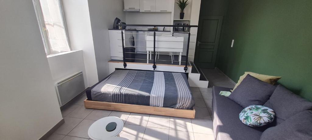 a small bedroom with a bed and a couch at Appartement studio Dole Grevy deux étoiles in Dole