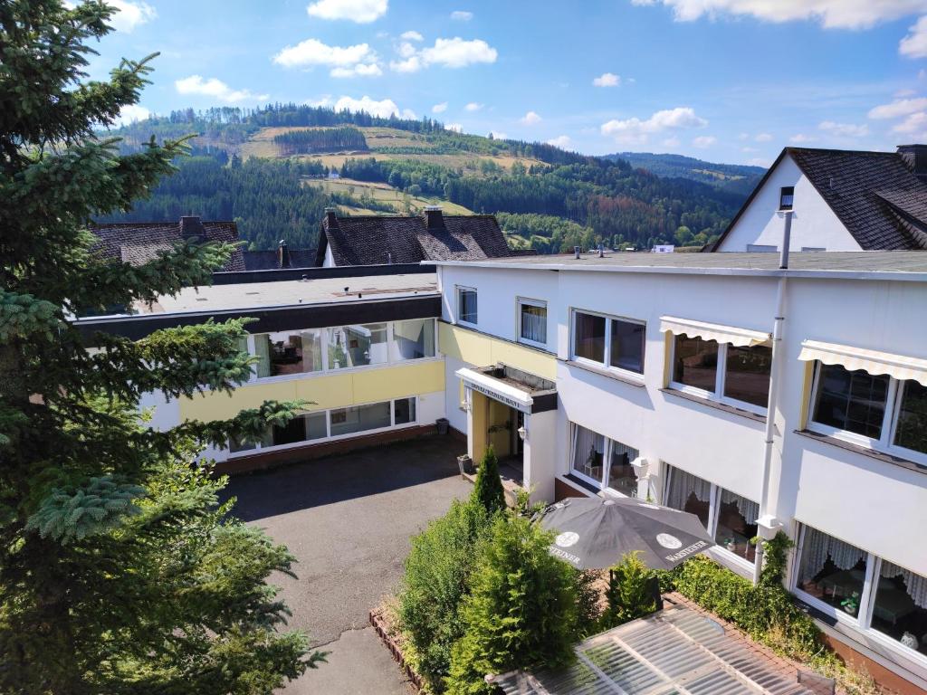 an aerial view of a building with mountains in the background at Berghotel Natura Bed & Breakfast in Winterberg