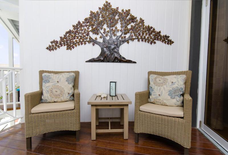 two chairs and a table with a tree on the wall at Lantana Resort Barbados by Island Villas in Saint James