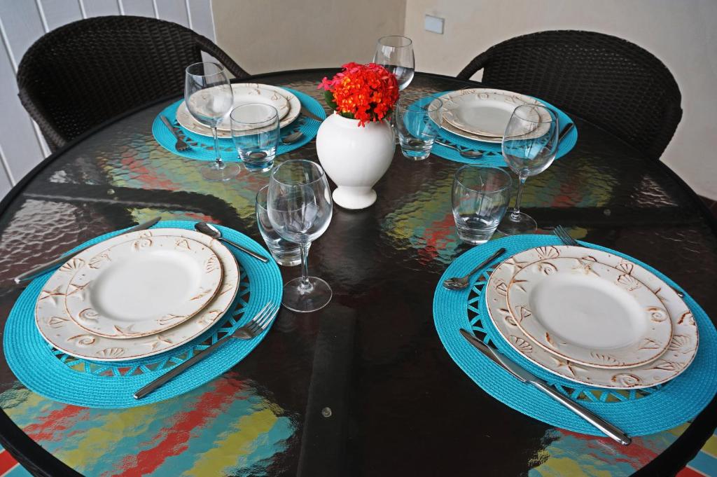 a table with plates and glasses and a vase with flowers at Lantana Resort Barbados by Island Villas in Saint James