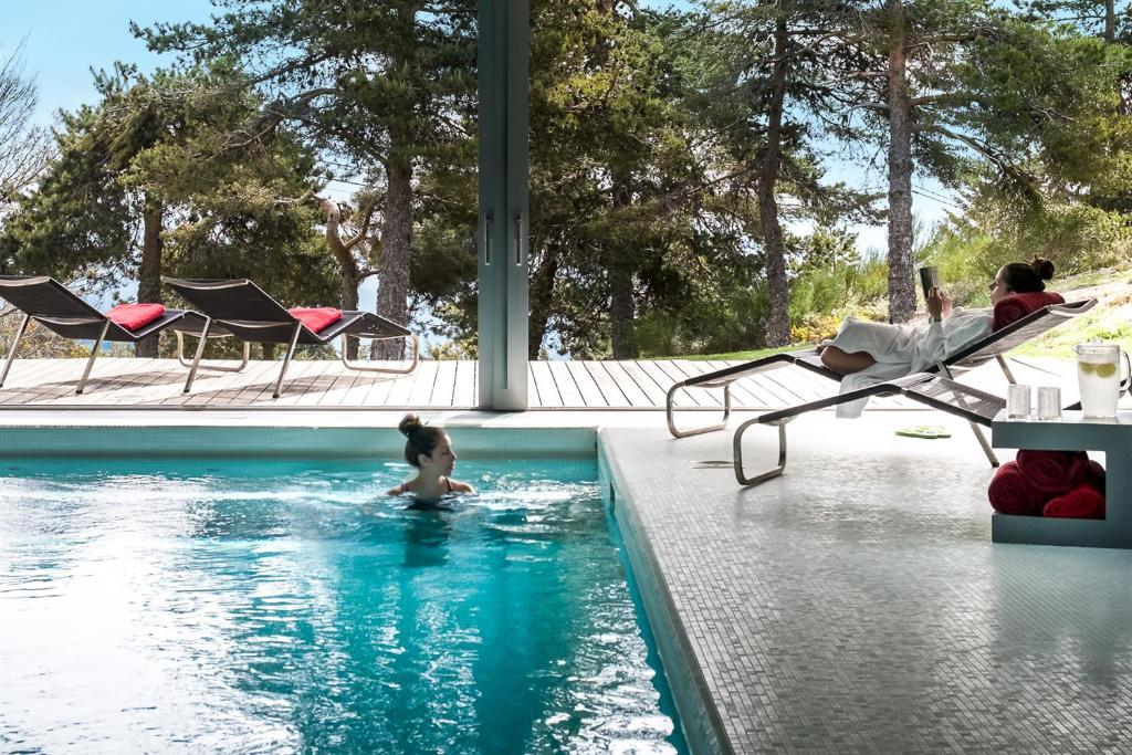 una mujer nadando en una piscina en Casa das Penhas Douradas - Burel Mountain Hotels, en Manteigas