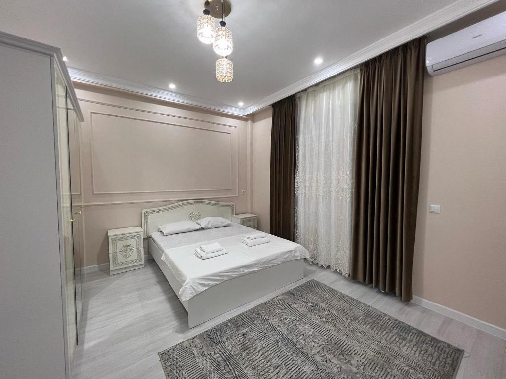 um quarto com uma cama e uma grande janela em Караван Сарай 3 em Türkistan
