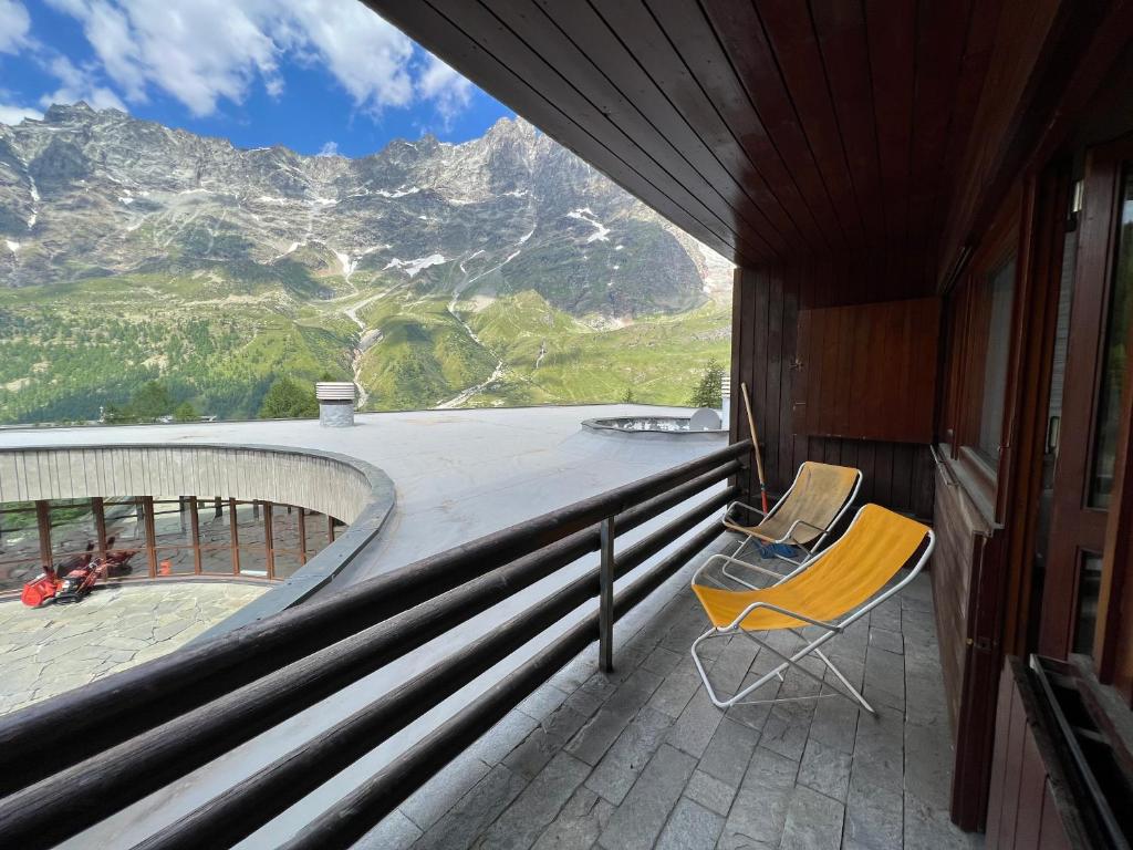 a chair on a balcony with a view of a mountain at Appartamento I Dadi Cervinia in Breuil-Cervinia