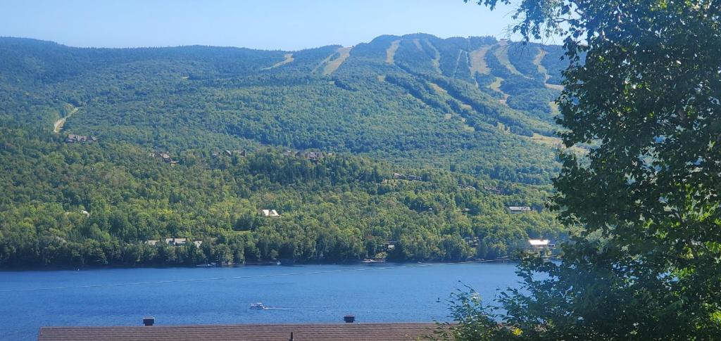 a view of a lake with mountains in the background at Beautiful suite with superb mountain view. in Mont-Tremblant