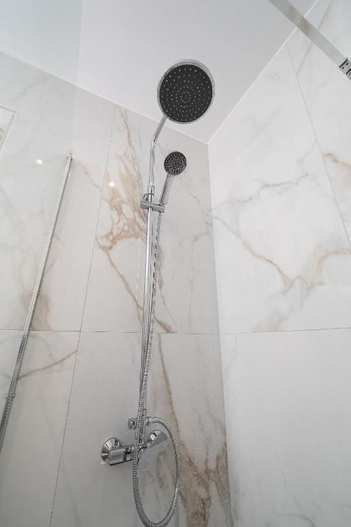 a shower in a bathroom with white marble at Amalia in Matala