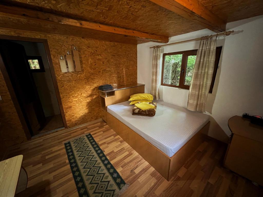 a small room with a bed and a window at Pensiunea Ionela in Zemeş