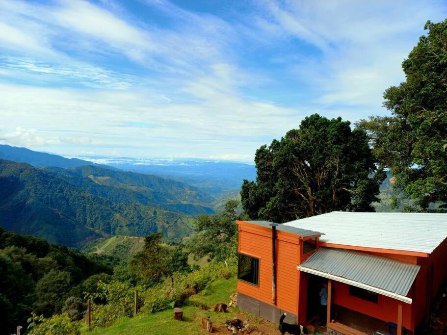 uma casa laranja numa colina com vista para as montanhas em Casa de campo Jaulares em Alaska