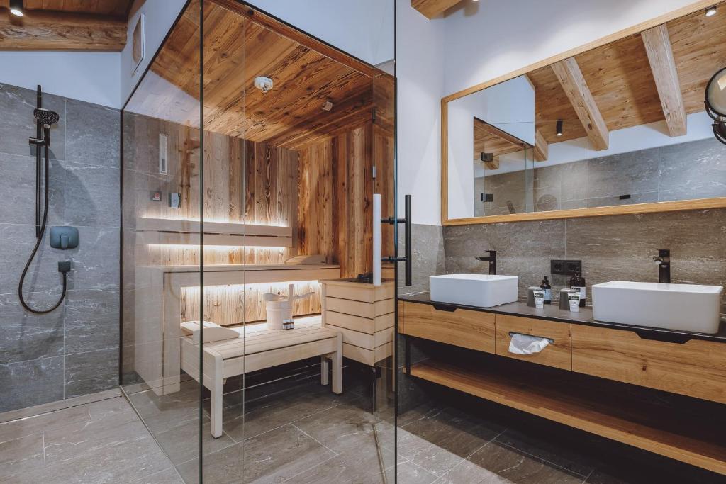 a bathroom with two sinks and a shower at Bergdorf Hotel Zaglgut in Kaprun