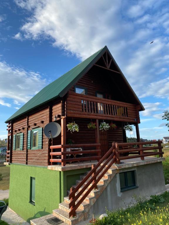 a log cabin with a green roof at Apartments Bulatovic in Žabljak