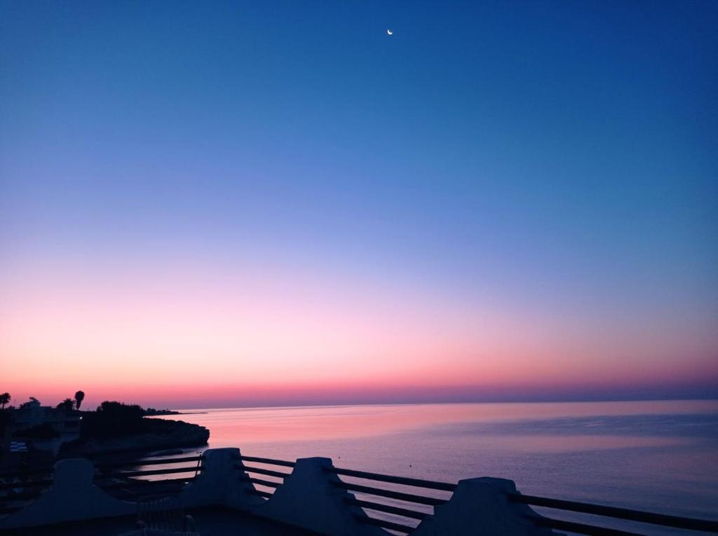 uma vista para o pôr-do-sol do oceano com o céu em La riva em Noto Marina