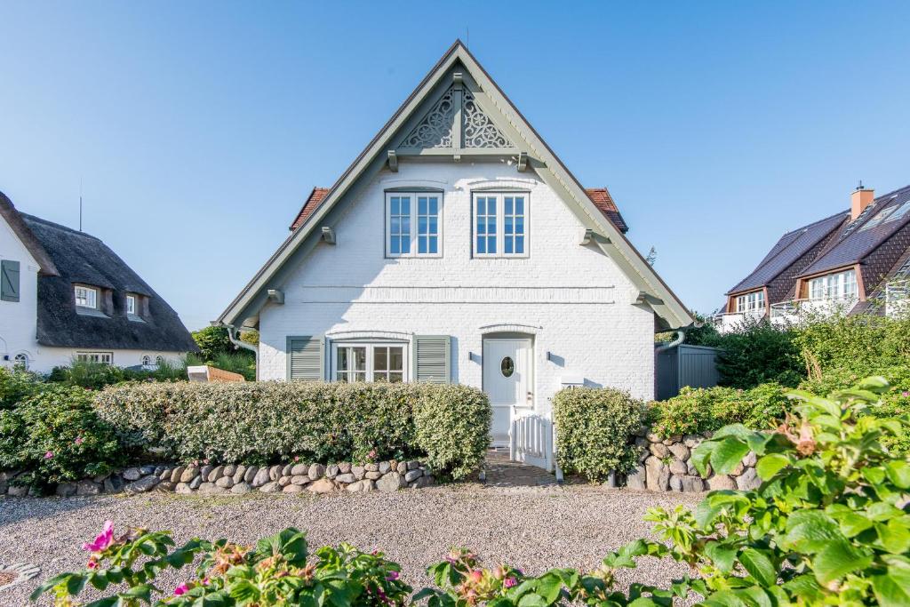 uma casa branca com um gambrel em Landhaus Hygge em Wenningstedt