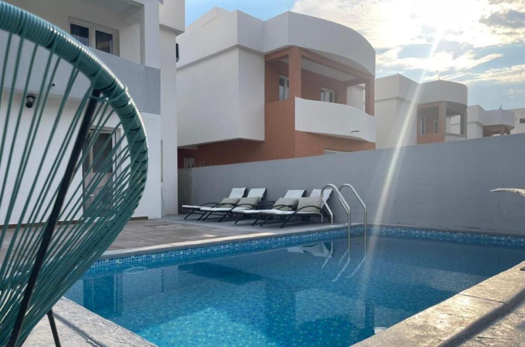 uma piscina com cadeiras ao lado de um edifício em Villa Olive Hill em Dobra Voda