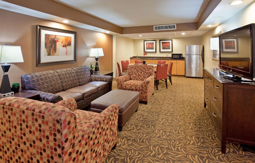um quarto de hotel com sofás e uma televisão e uma cozinha em Holiday Inn Kearney, an IHG Hotel em Kearney