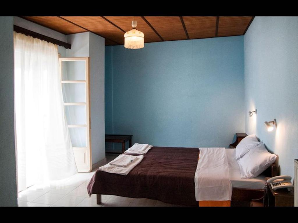 a bedroom with a bed with a blue wall at Room in BB - The Quality And Hospitalityof Apraos Bay Hotel Has Been Identified in Apraos