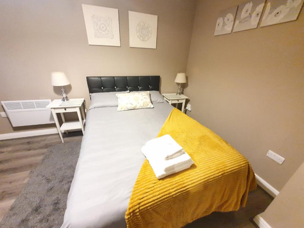 - une chambre avec un grand lit et une couverture jaune dans l'établissement The Savile, Luxury Apartment Leeds - Your Next Stay, à Leeds