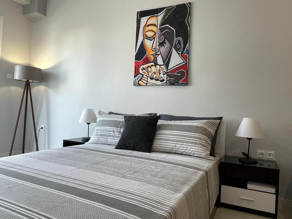 1 dormitorio con 1 cama con una pintura en la pared en Modern Apartment 305, en Xanthi