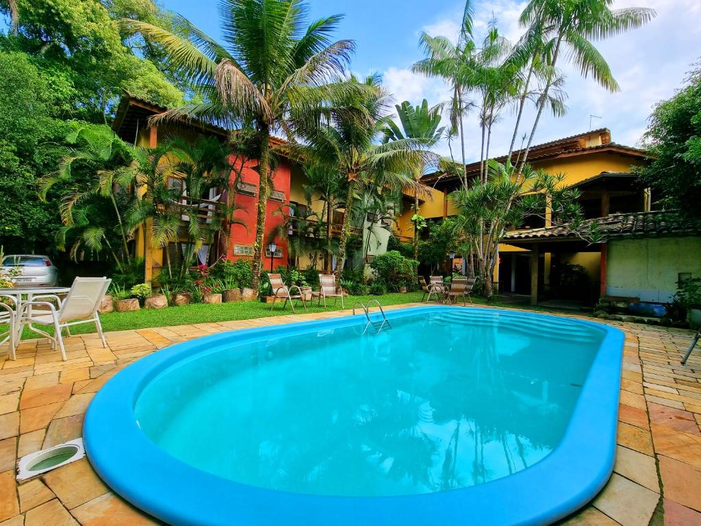 a swimming pool in front of a house at Pousada Rumo dos Ventos in Paraty