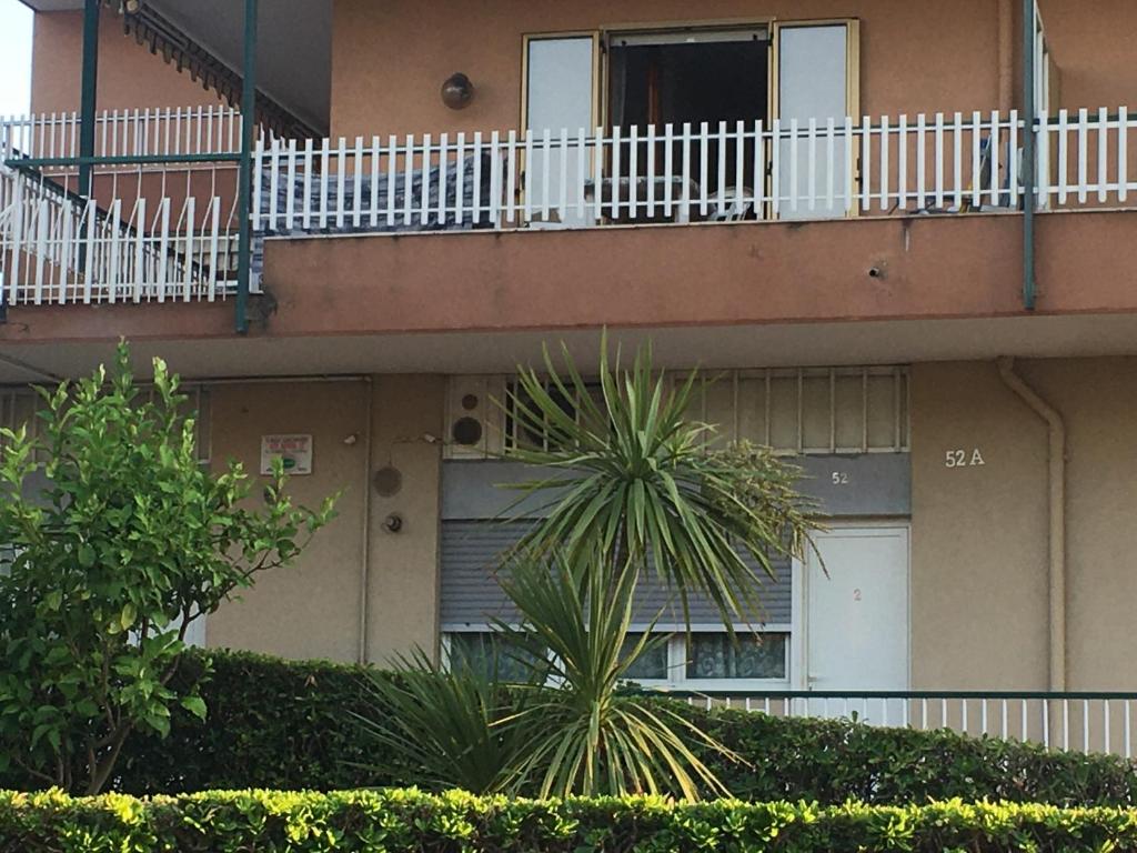 ヴェンティミリアにあるMonolocale Via Nerviaのドアとバルコニー付きのアパートメントビル