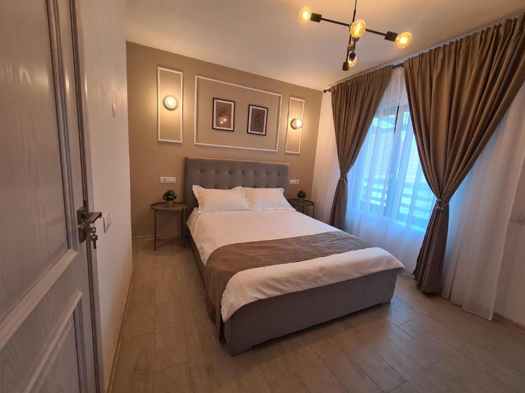 a bedroom with a large bed and a window at URBANIST Guest House in Călimăneşti