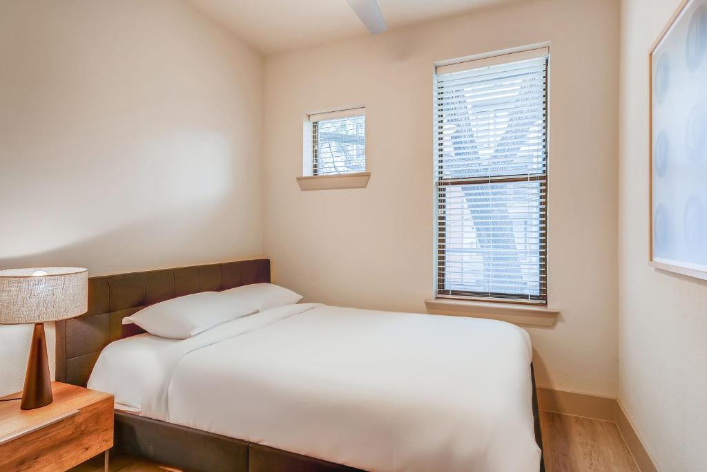 una piccola camera con un letto e due finestre di Sentral East Austin at 1630 E Sixth ad Austin