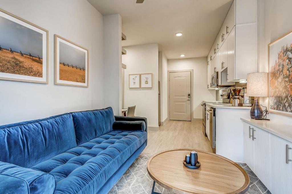 un soggiorno con un divano blu e un tavolo di Sentral East Austin at 1630 E Sixth ad Austin