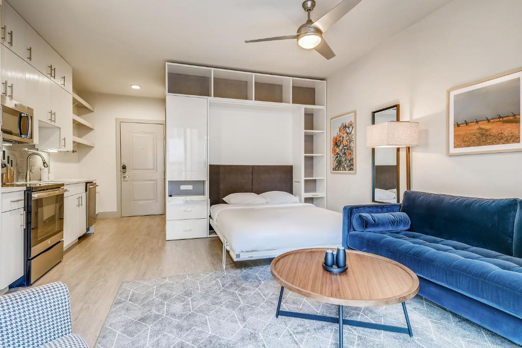 un soggiorno con divano blu e letto di Sentral East Austin at 1630 E Sixth ad Austin