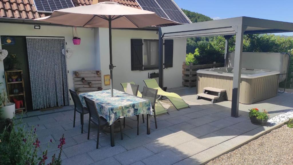 a patio with an umbrella and a table and chairs at The Primevères Home - SPA in Sainte-Marie-aux-Mines