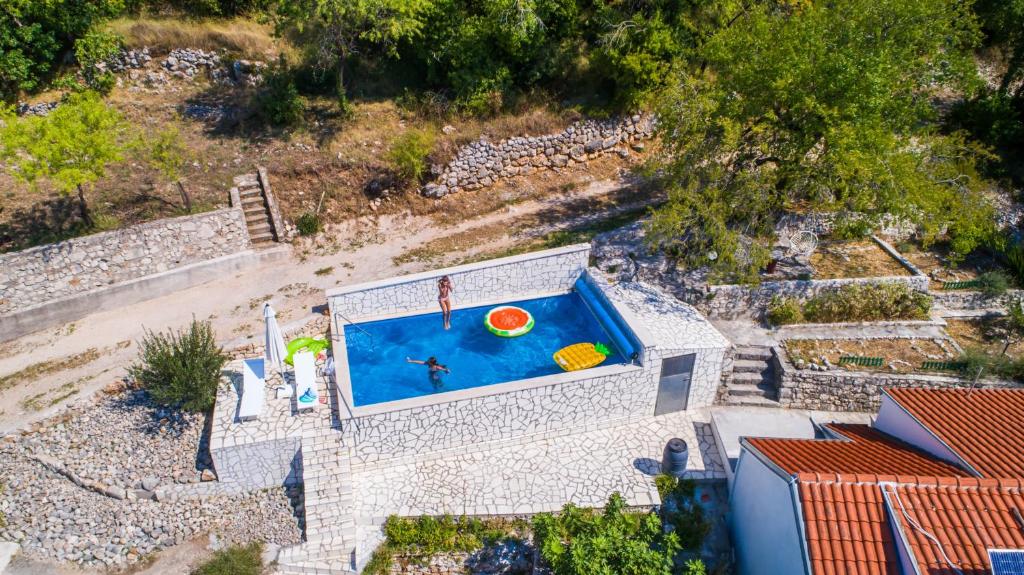 uma vista superior de uma piscina com uma pessoa e uma bola em Eco Villa with Pool em Podaca