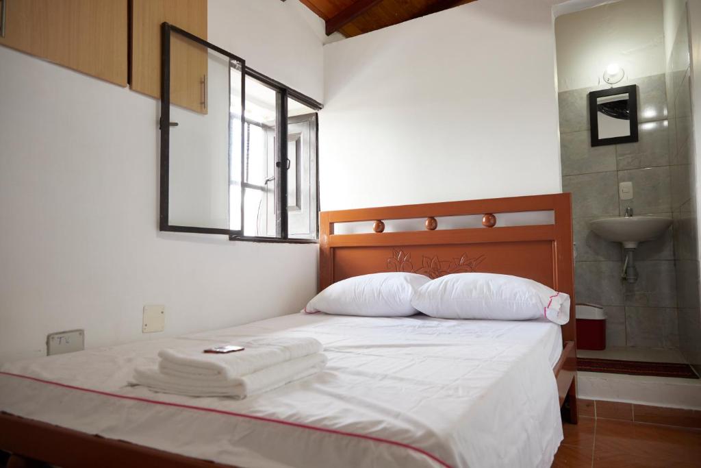 1 dormitorio con 1 cama con toallas en Hotel Gran Girones, en Girón