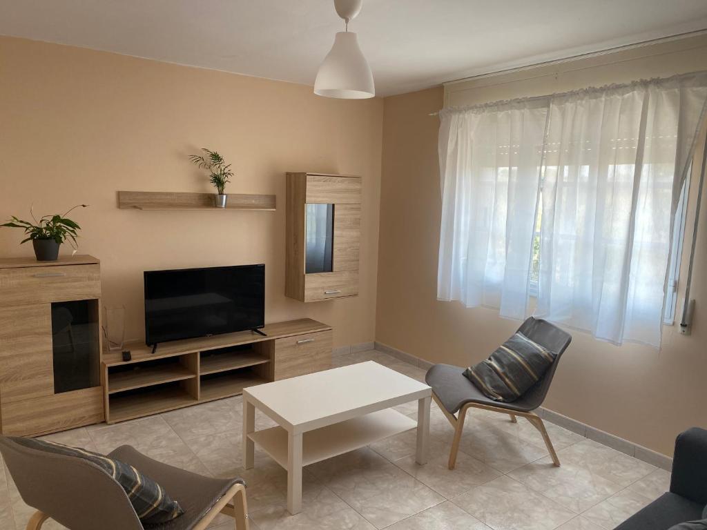 a living room with a tv and a table and chairs at Apartamento en Rias Baixas-Aguiño-Ribeira in Ribeira