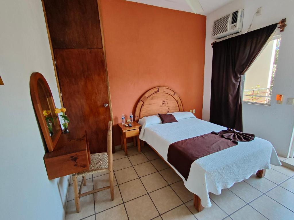 a bedroom with a large bed and a window at Hotel & Bungalows La Casa de Fortu in San Blas