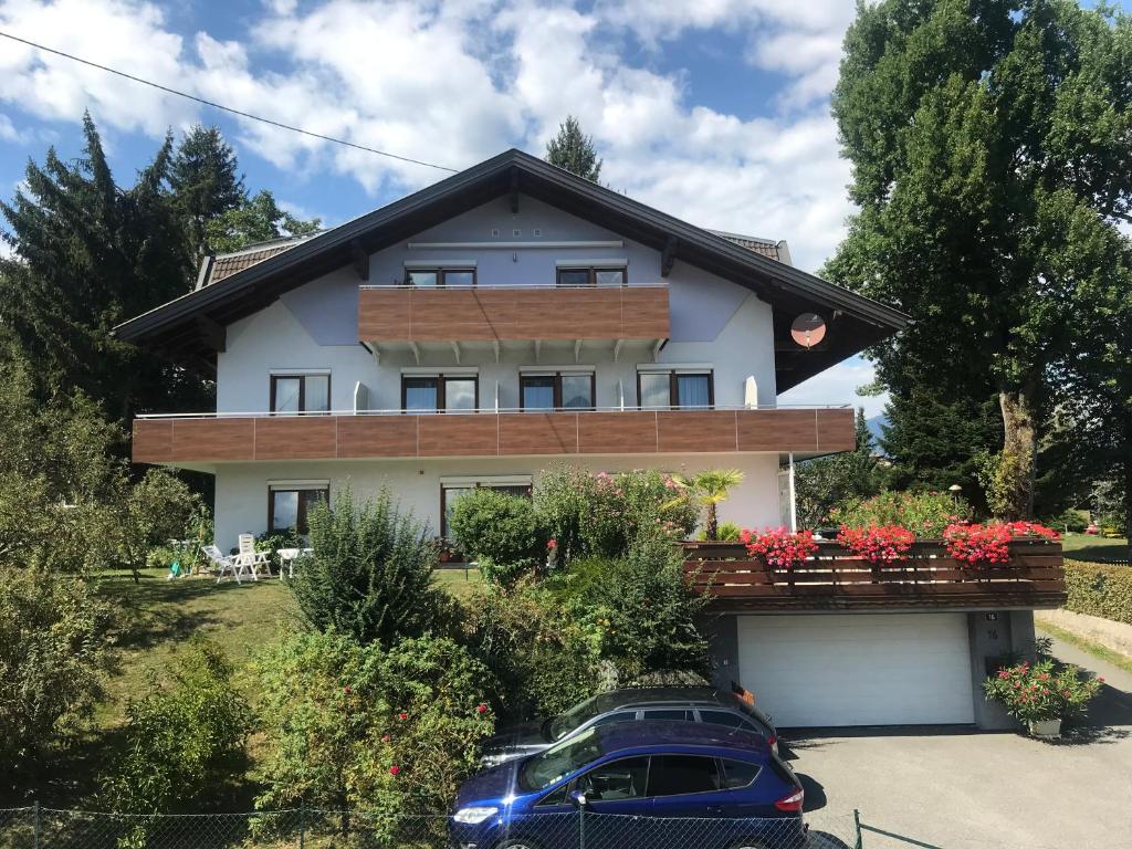 una casa con coches aparcados delante de ella en Gästehaus Uggowitzer, en Drobollach am Faakersee