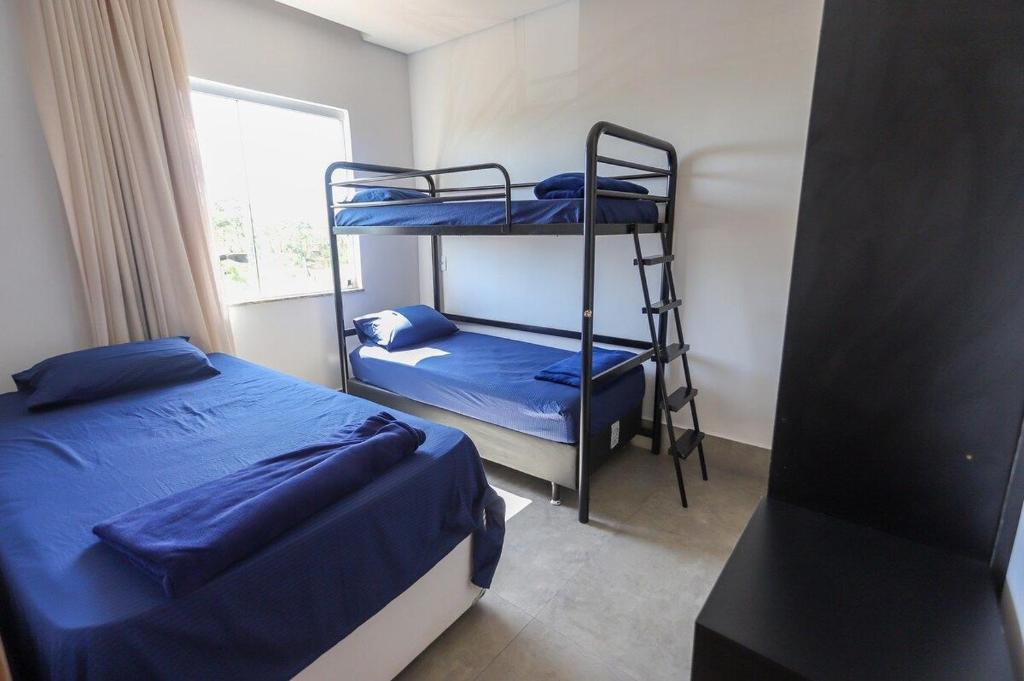a bedroom with two bunk beds and a window at Complexo Alpes do Cerrado in Sobradinho