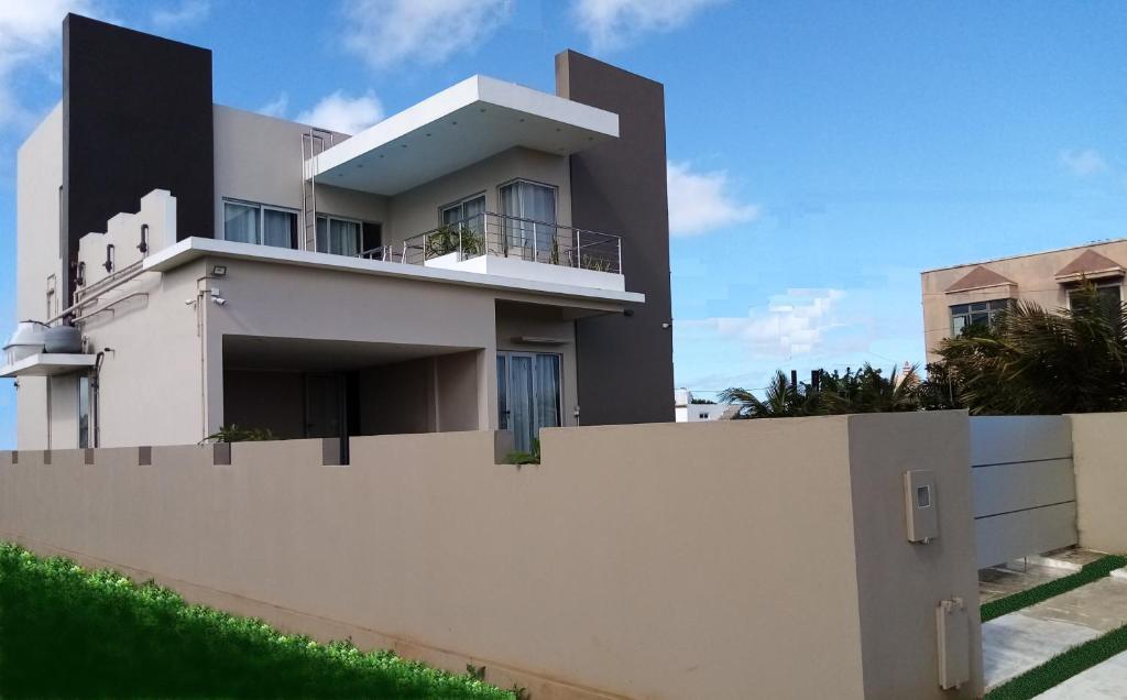 a white house behind a white fence at ISLAND RESIDENCE Plaisance - Mauritius - 15718 in Plaine Magnien