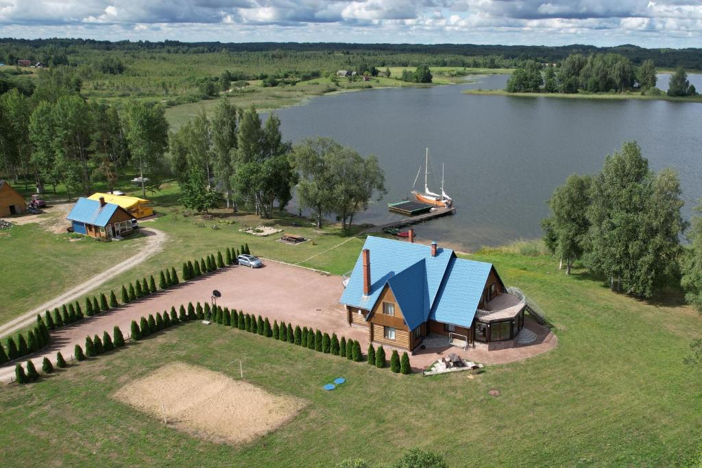 een eiland met een huis en een boot op een meer bij Buru Guru viesu nams Zīdu kolns in Čornaja