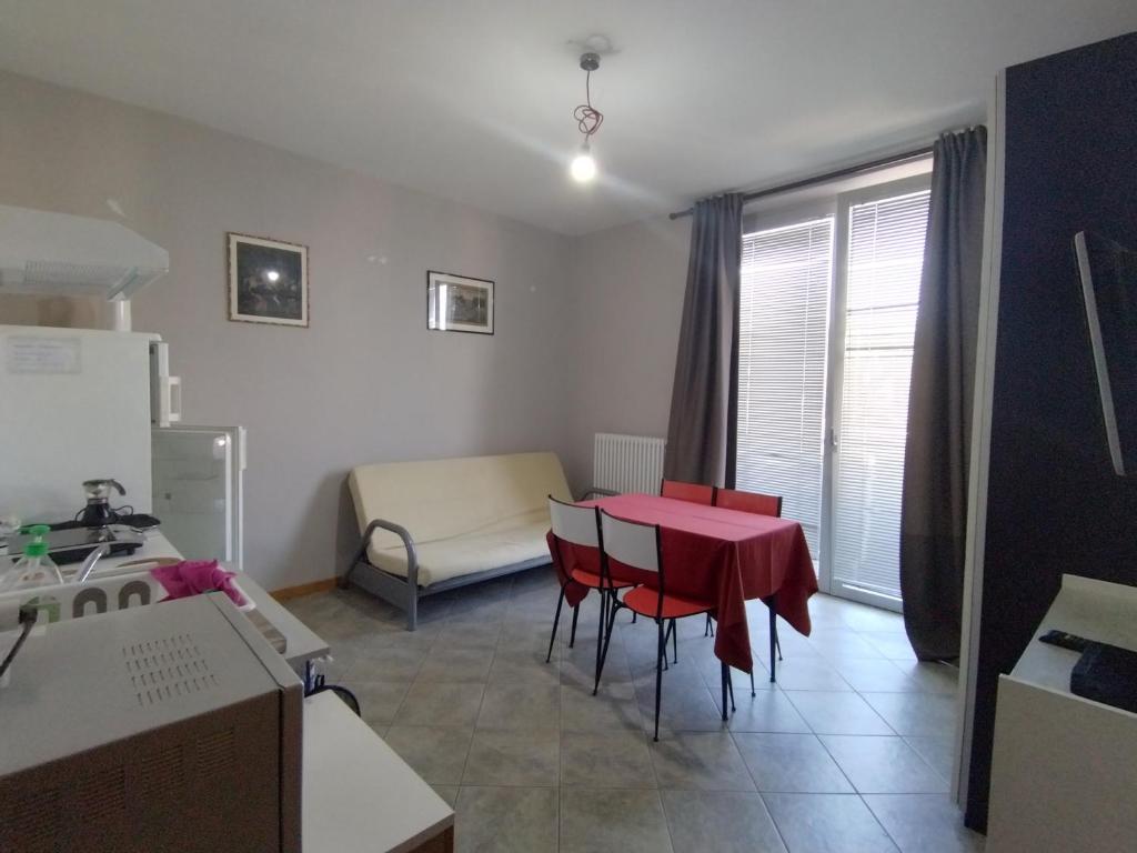 een keuken met een rode tafel en stoelen in een kamer bij Soggiorno Manu in Cantù