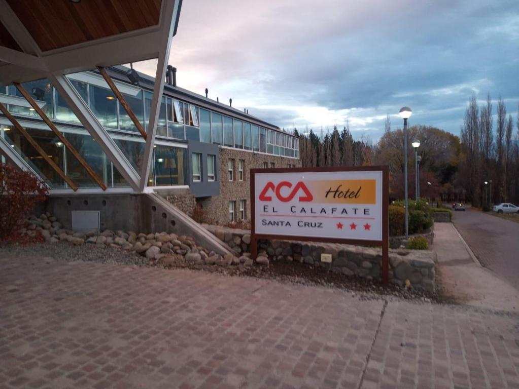 un bâtiment avec un panneau devant un bâtiment dans l'établissement Hotel ACA El Calafate, à El Calafate