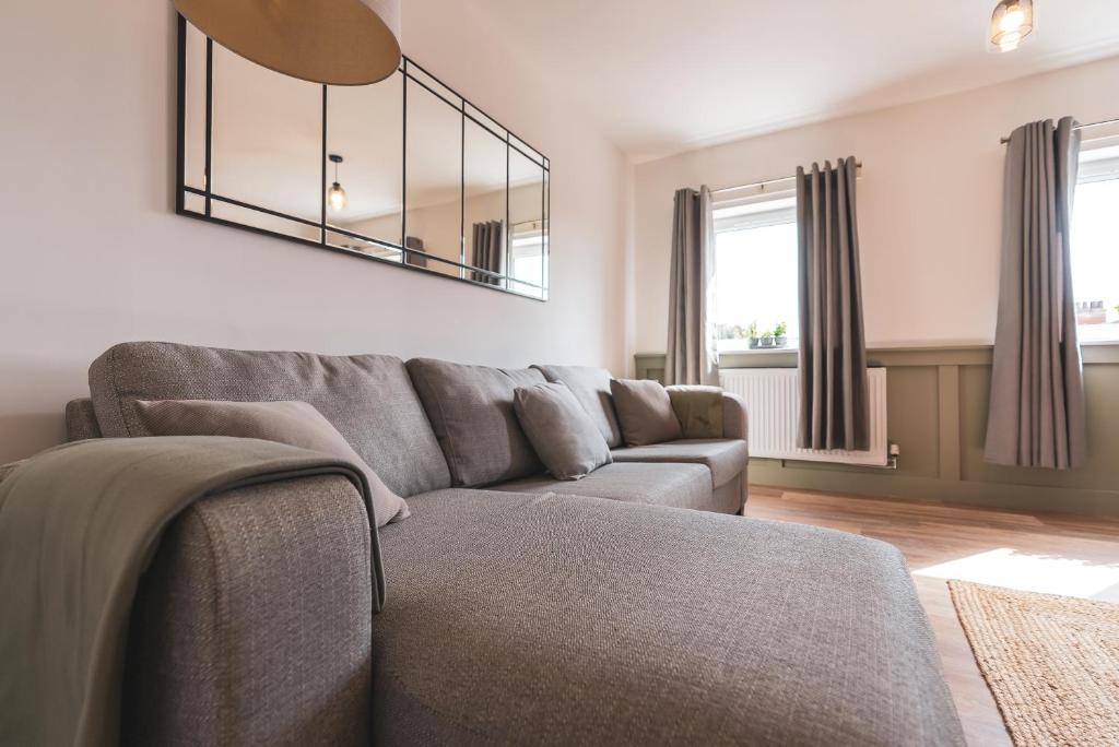 a living room with a couch and a mirror at The Old Band Accommodation in Higham Ferrers