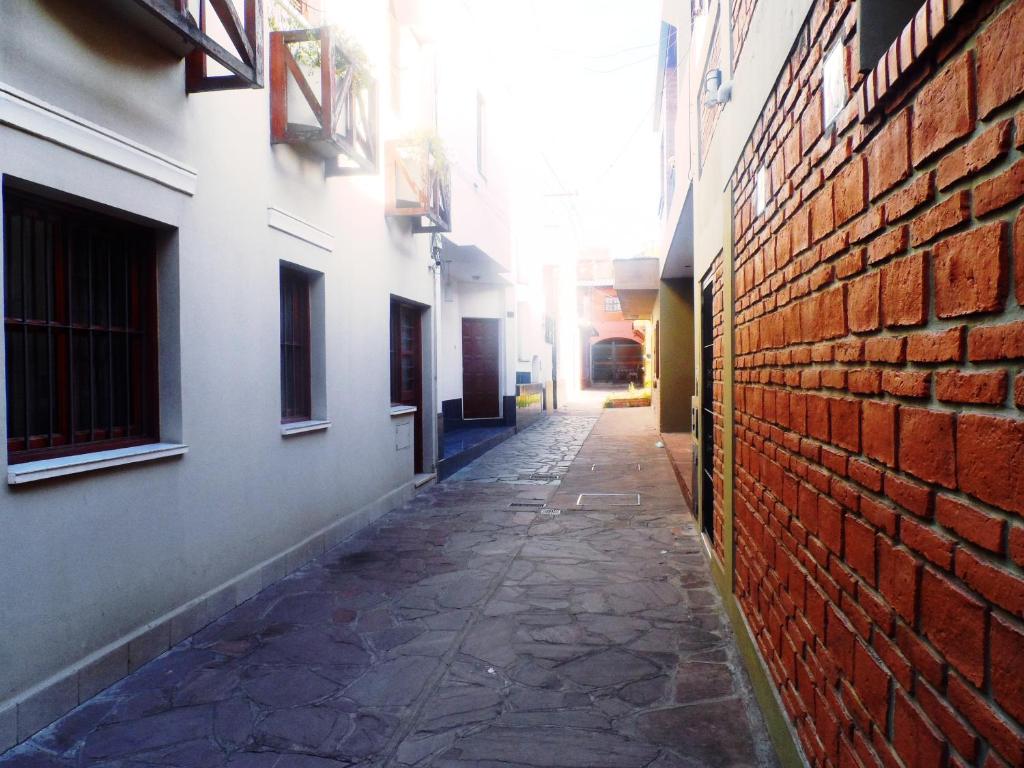 an alley between two buildings with a brick wall at LA BIANCA in San Salvador de Jujuy