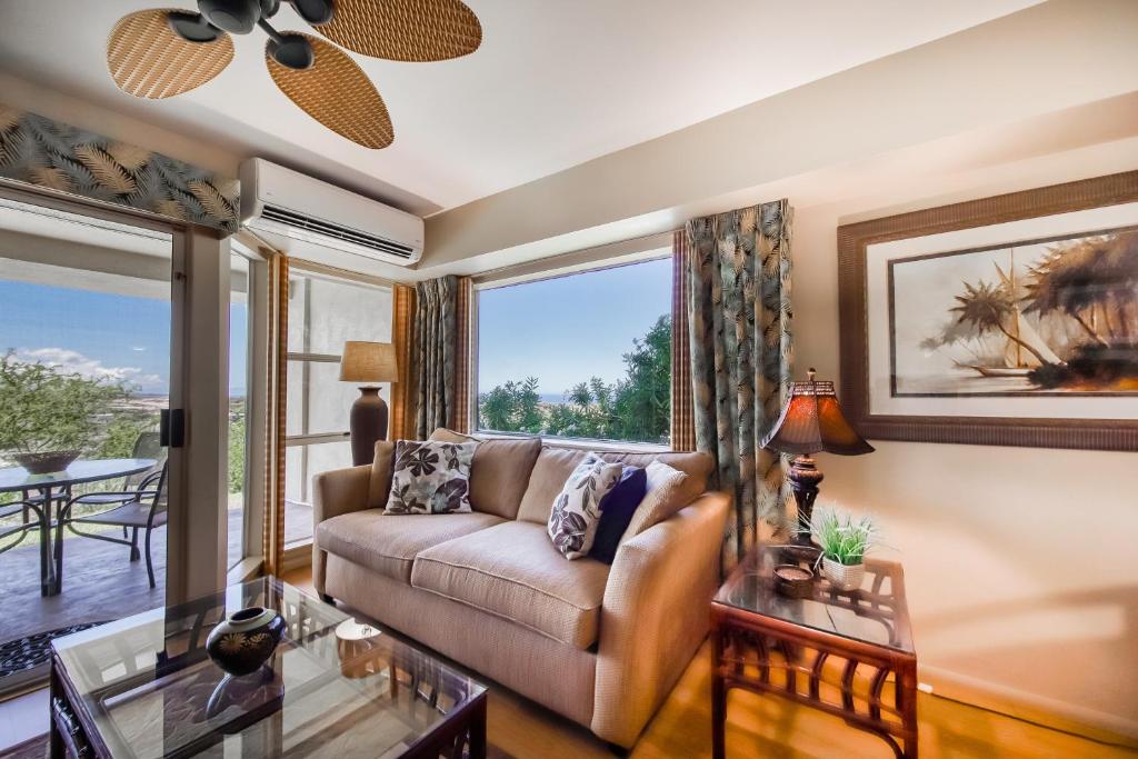 a living room with a couch and a large window at Greens At Waikoloa L101 in Waikoloa Village