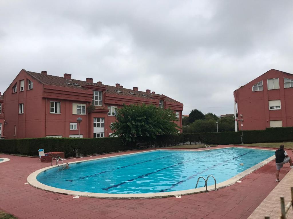 una gran piscina frente a un edificio en Ático La Canal, en Santa Cruz de Bezana