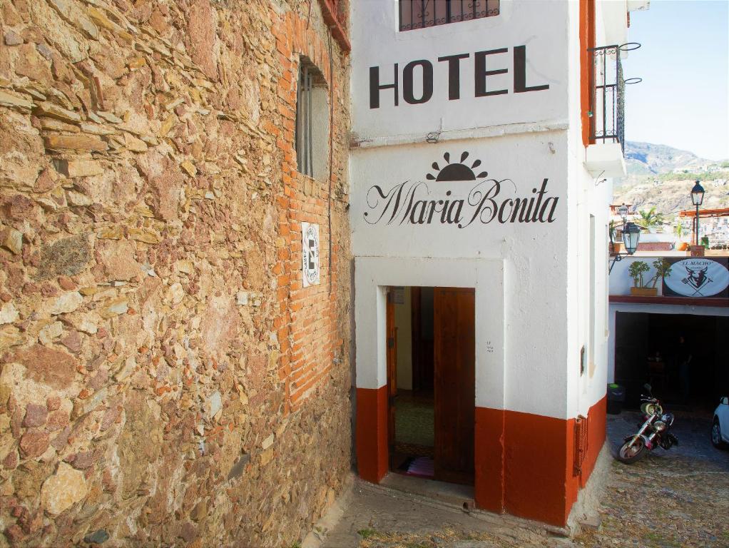 un panneau d'hôtel sur le côté d'un bâtiment en briques dans l'établissement María Bonita by Rotamundos, à Taxco